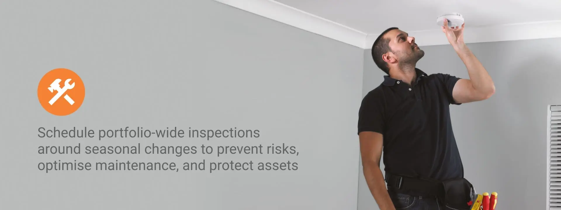 Schedule portfolio-wide inspections around seasonal changes. A tradesman fitting a FireAngel alarm. 